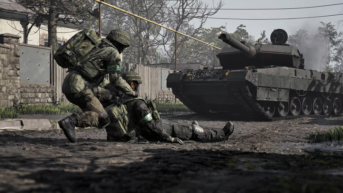 Zwei Soldaten hinter einer Mauer, ein Kampfpanzer rollt vorbei, ein Verwundeter liegt am Boden.